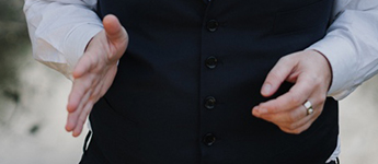 Matsui's hands in an engaged speaking position. One hand is opened the other is held naturally.